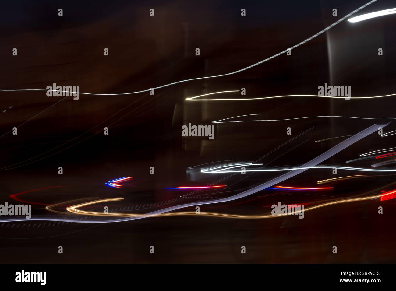Foto notturna di un viale di edifici con strisce colorate. Le strisce sono il riflesso delle luci e dei lampioni dell'auto. La foto ha una a scura Foto Stock
