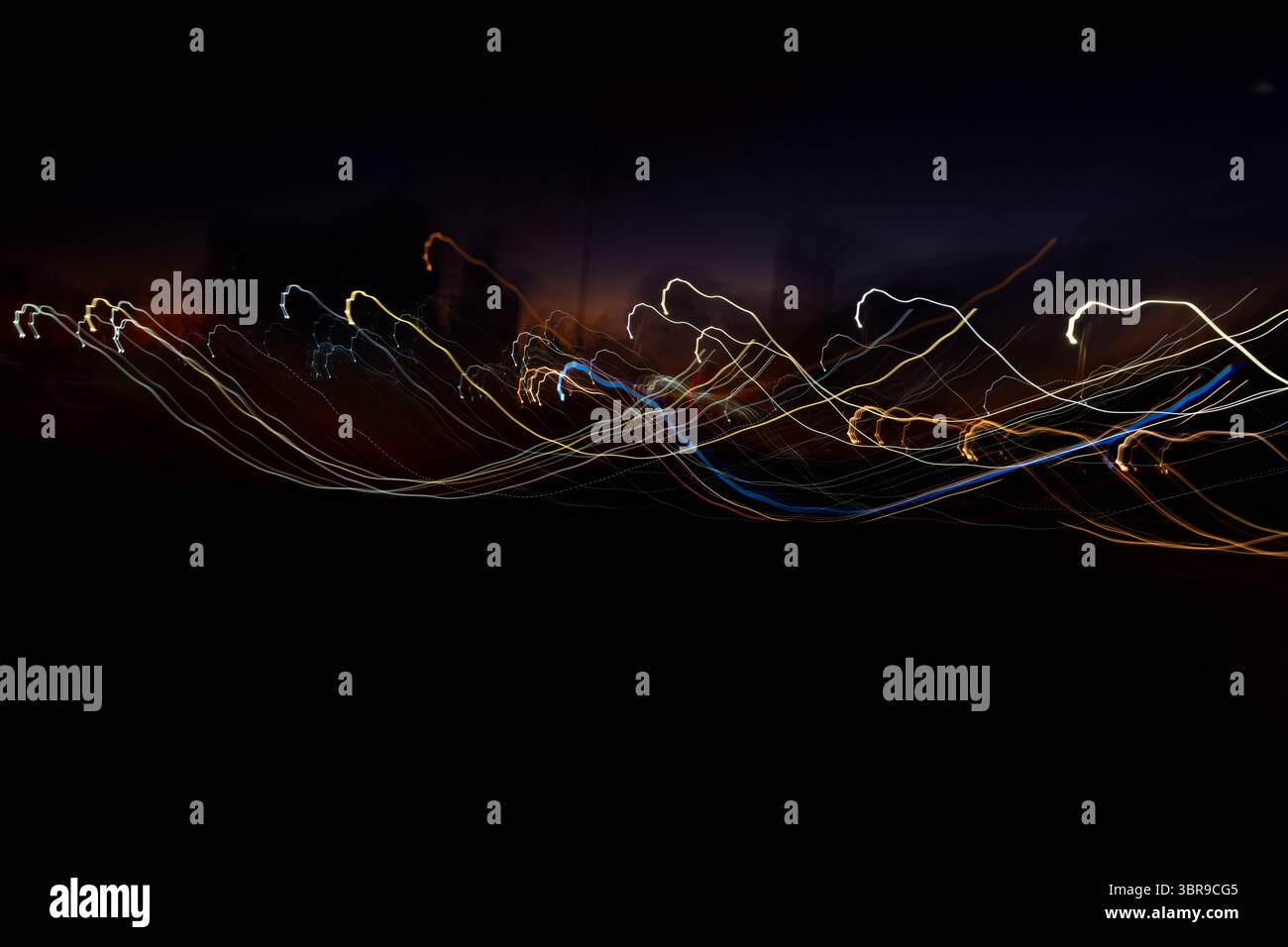Foto notturna di un viale di edifici con strisce colorate. Le strisce sono il riflesso delle luci e dei lampioni dell'auto. La foto ha una a scura Foto Stock
