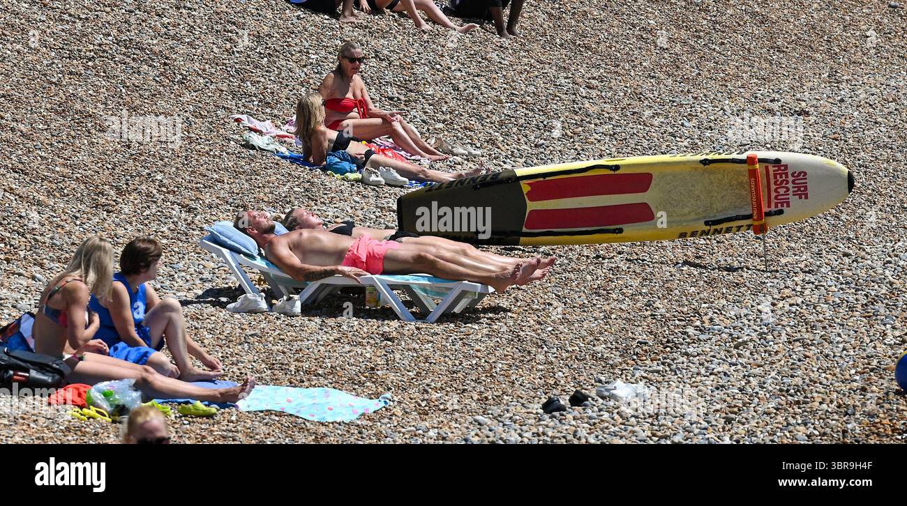Brighton Regno Unito 11 luglio 2025 - le folle godono del caldo sole sulla spiaggia di Brighton durante la terza ondata di caldo dell'estate finora con temperature negli anni '30 di nuovo in alcune parti della Gran Bretagna: Credit Simon Dack / Alamy Live News Foto Stock