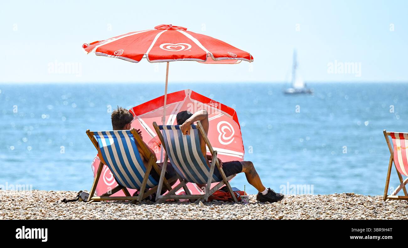 Brighton Regno Unito 11 luglio 2025 - le folle godono del caldo sole sulla spiaggia di Brighton durante la terza ondata di caldo dell'estate finora con temperature negli anni '30 di nuovo in alcune parti della Gran Bretagna: Credit Simon Dack / Alamy Live News Foto Stock