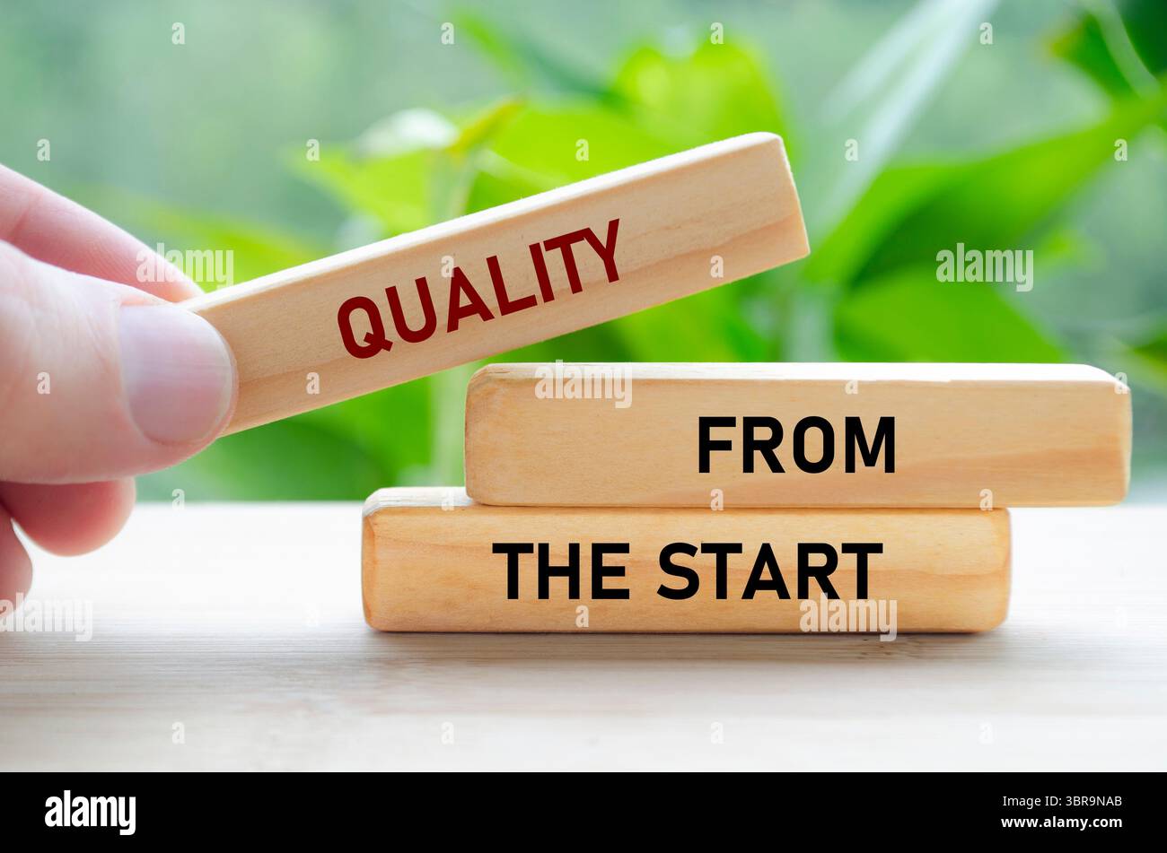 Il testo di qualità fin dall'inizio sui blocchi di legno in mano mostra una solida base posata fin dal primo giorno. Foto Stock