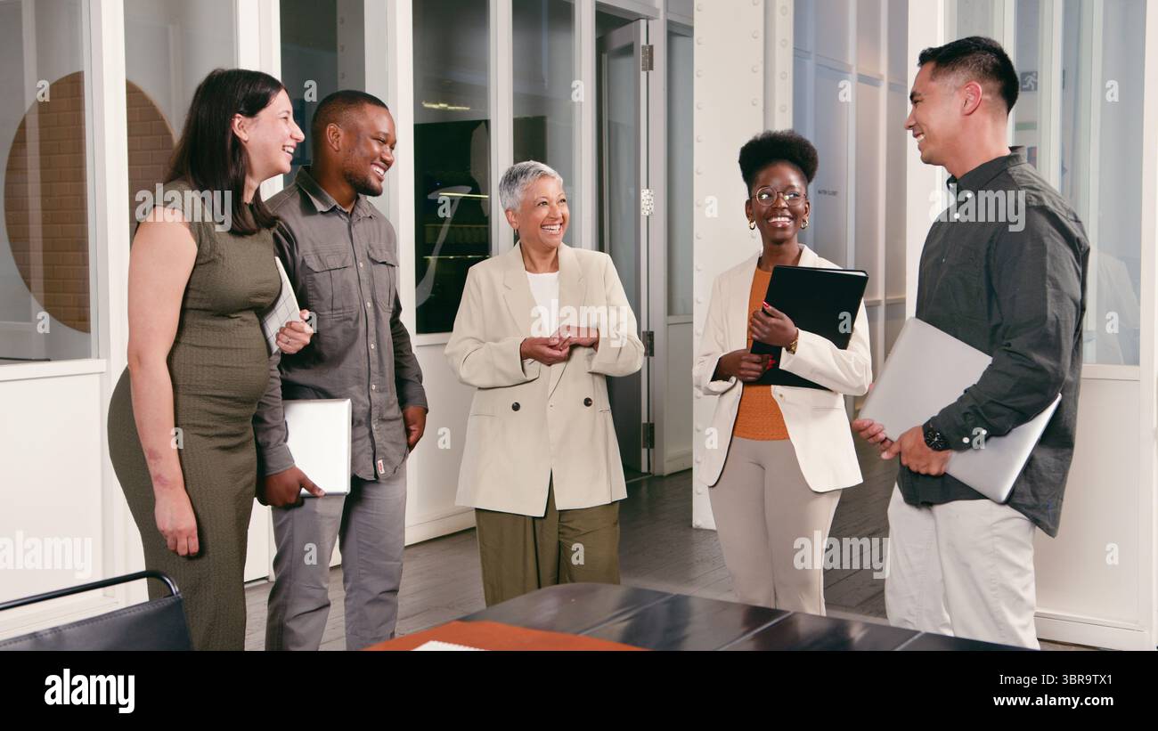 Team di professionisti impegnati in discussioni amichevoli in un ambiente d'ufficio moderno Foto Stock