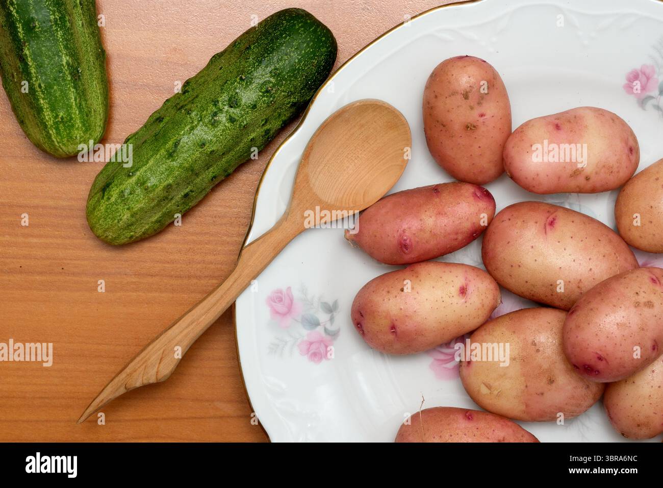 Le verdure raccolte disposte su un tavolo di legno invitano alla creatività culinaria. Foto Stock