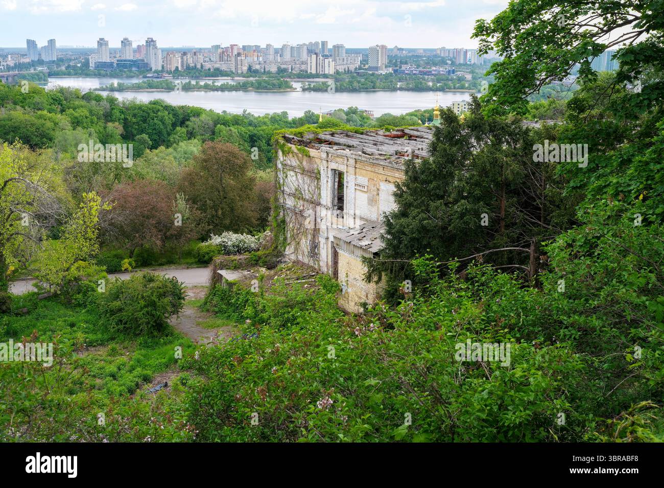 Le rovine sovrastate sorgono in cima a una collina, affacciate su un fiume tranquillo e sullo skyline della città. Foto Stock