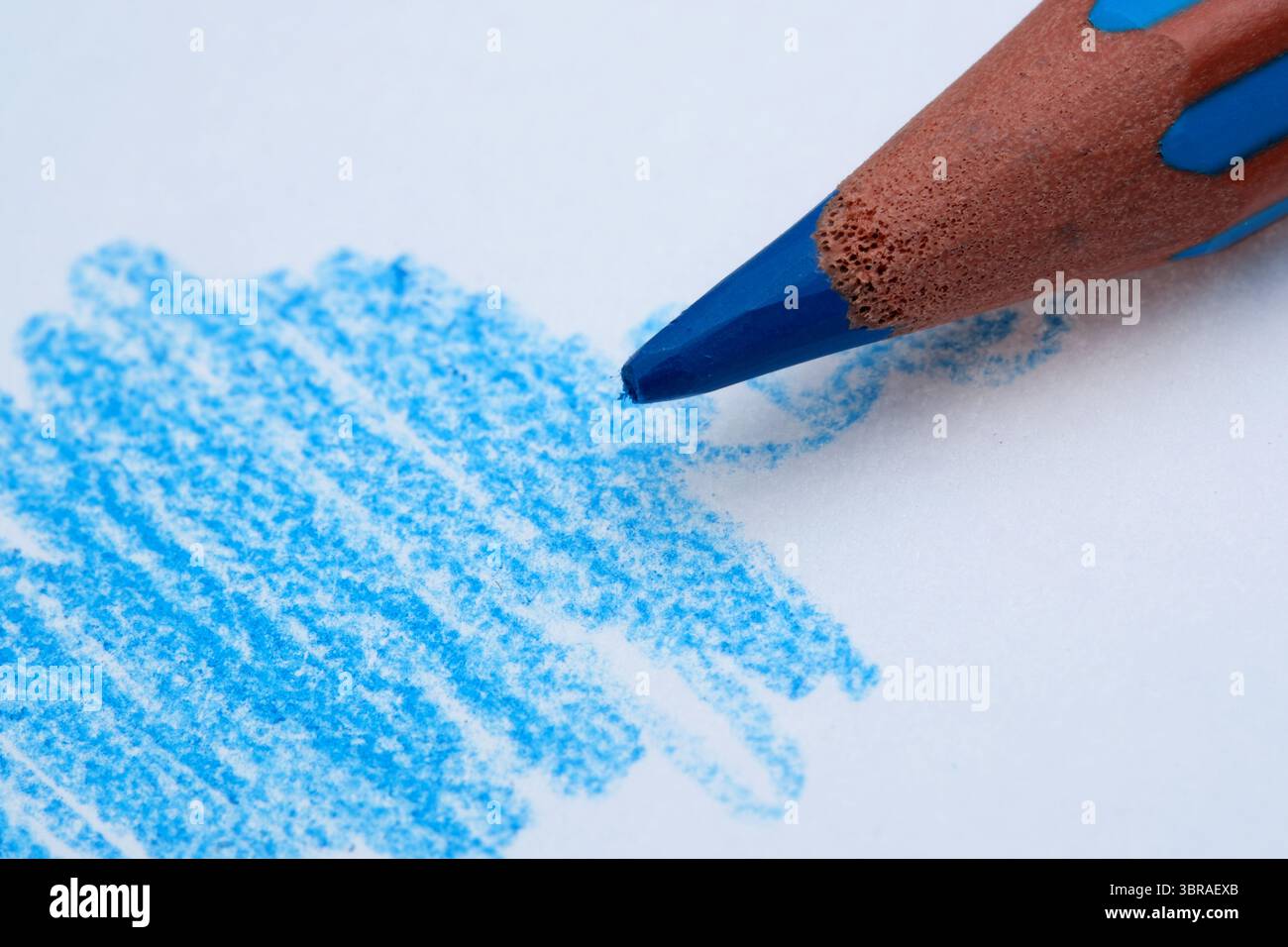I bambini esprimono la loro immaginazione utilizzando un pastello blu, catturando gioia. Foto Stock