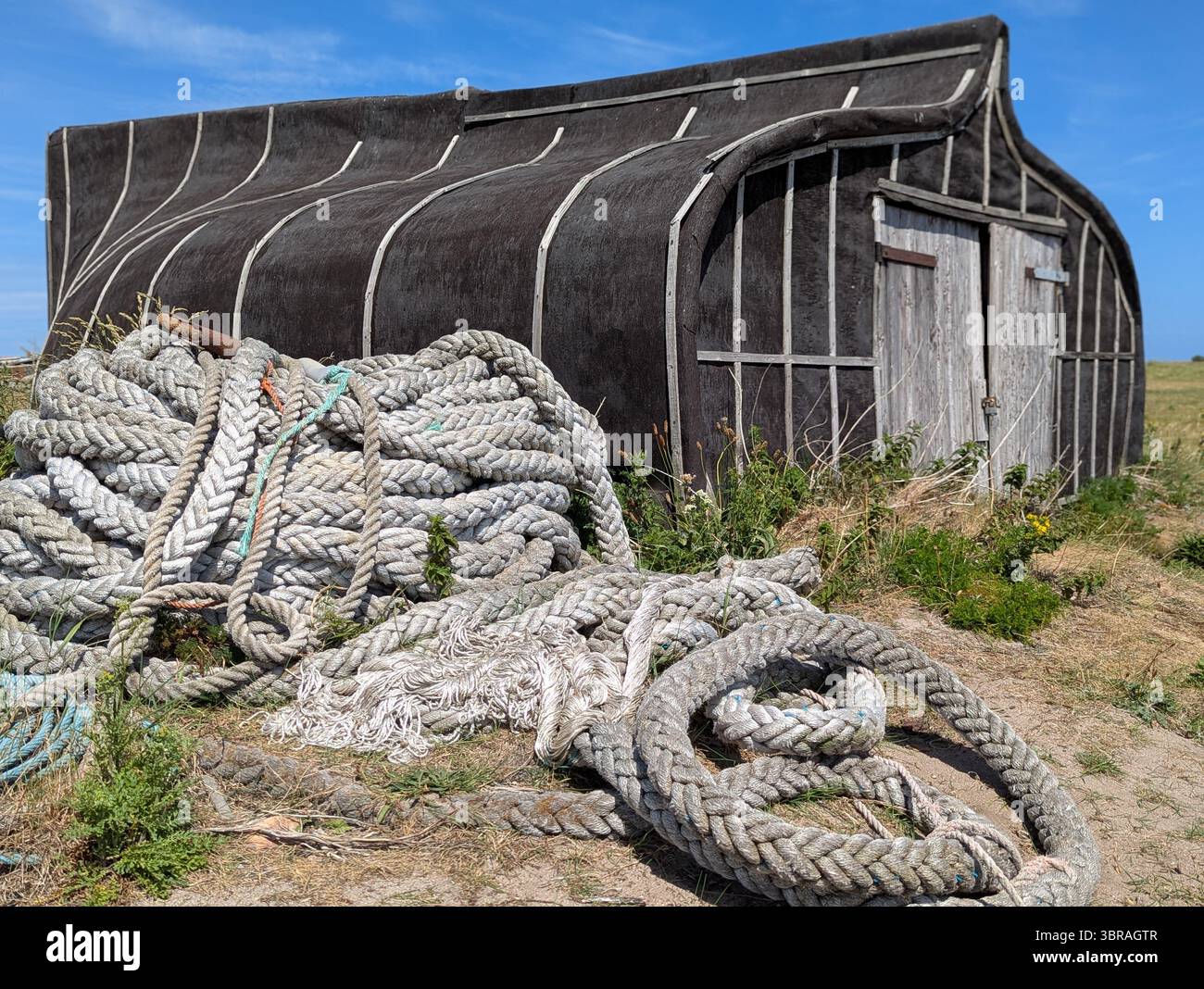 Bellezza rustica sull'Isola Santa: Le caratteristiche baracche di legno di Lindisfarne offrono uno scorcio sul carattere senza tempo e sulla costa dell'isola. Foto Stock