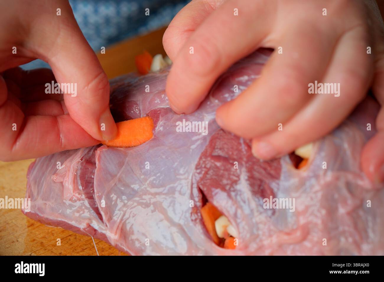 Le mani riempiono sapientemente la carne di verdure, mostrando arte culinaria. Foto Stock