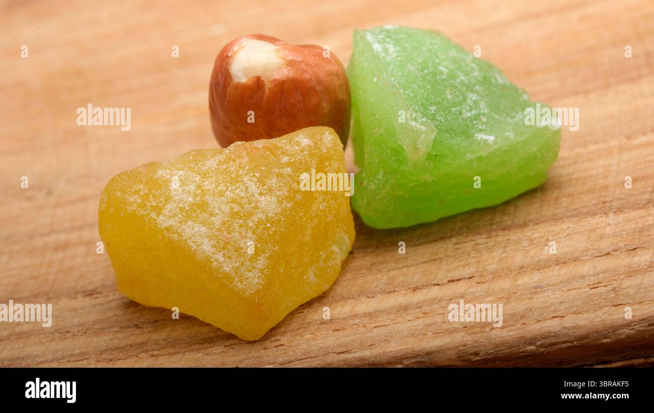 Pezzi di dolciumi dolci dai colori vivaci si trovano su una tavola di legno. Foto Stock