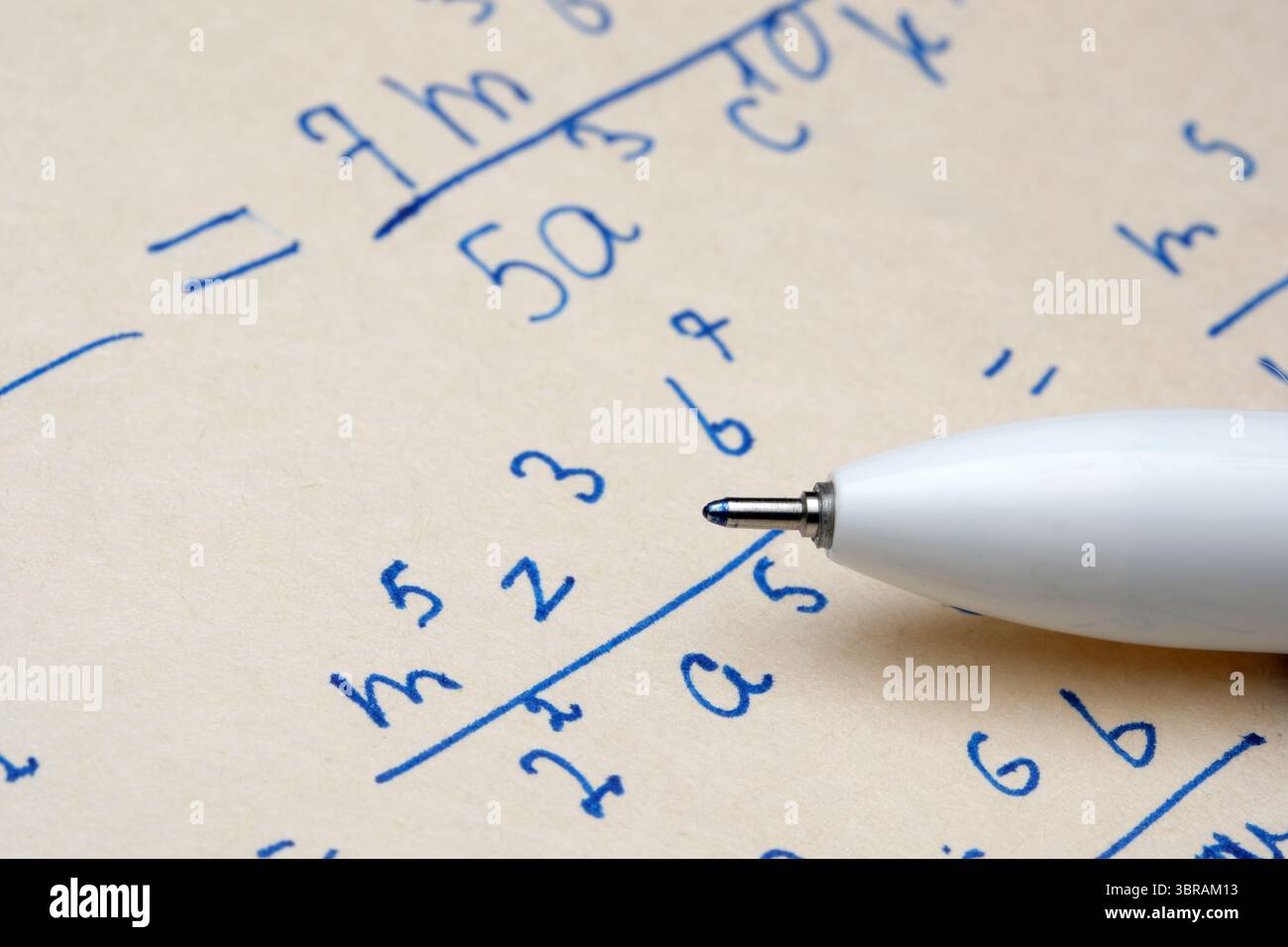 Vista ravvicinata di note matematiche dettagliate con una penna che poggia sulle equazioni. Foto Stock