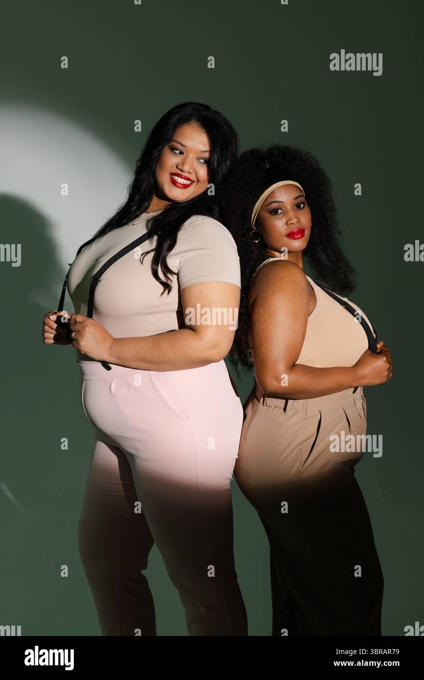 Diversi modelli femminili in posa in uno studio fotografico con bretelle e archetto Foto Stock