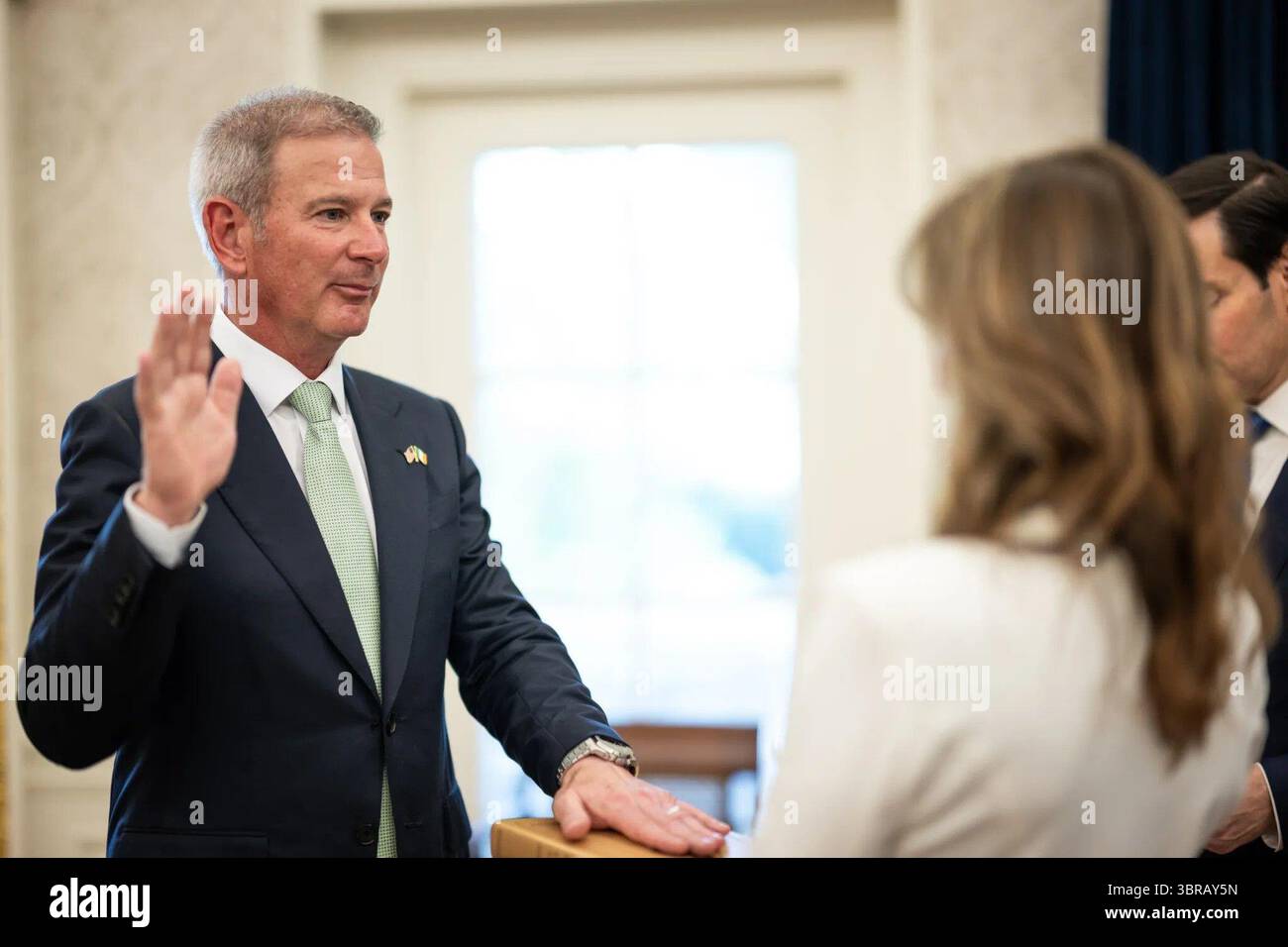 Edward Walsh alza la mano destra mentre giura come ambasciatore degli Stati Uniti in Irlanda presso l'Ufficio ovale della Casa Bianca, con il senatore Marco Rubio presente. Washington, D.C. 19 giugno 2025. Per gentile concessione della Casa Bianca. Foto Stock