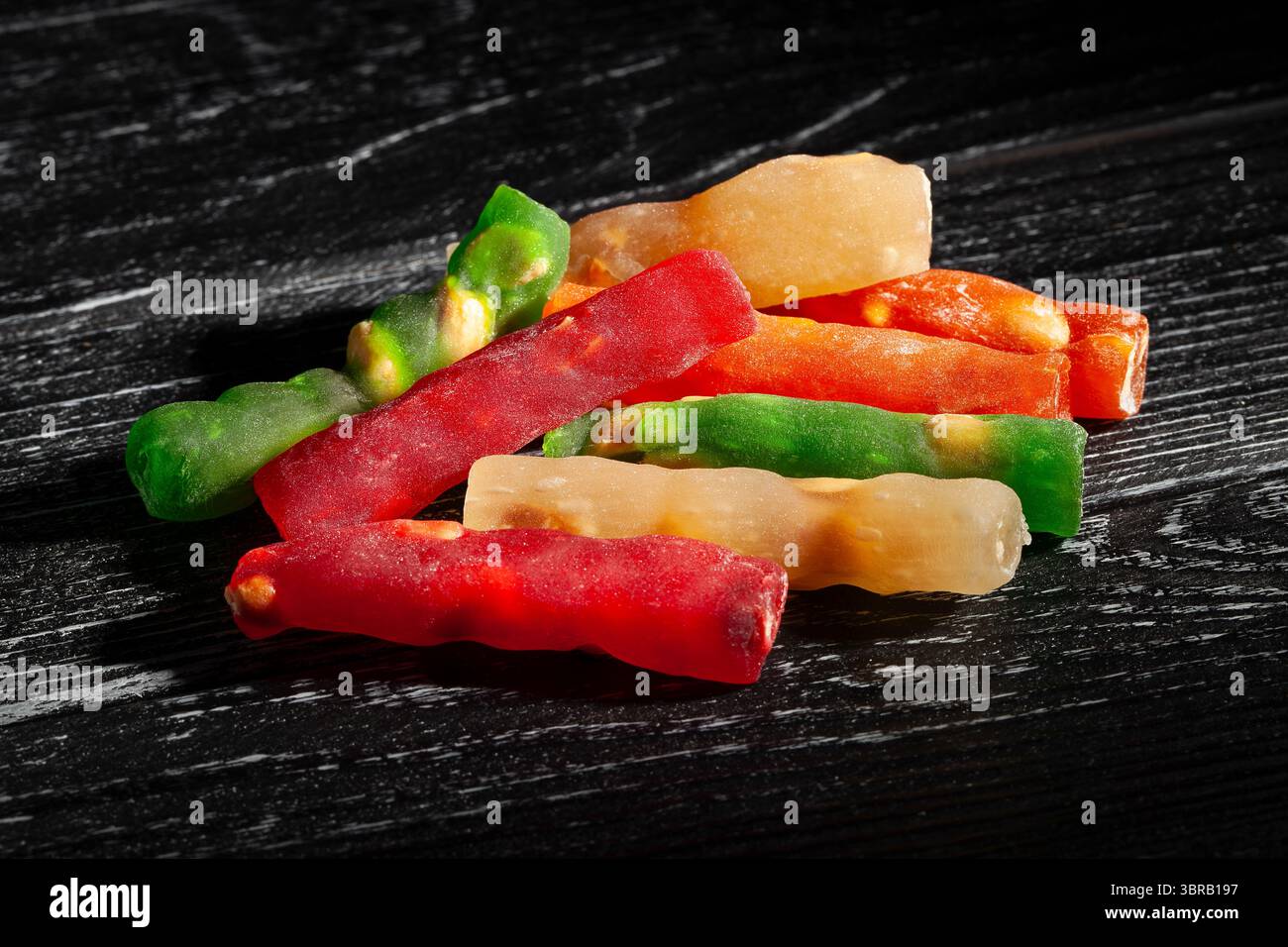 gelatina caramelle su fondo in legno nero Foto Stock