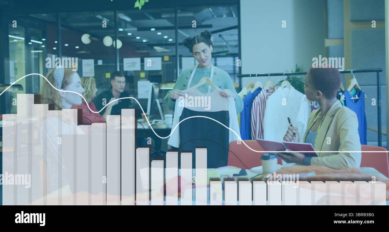 Stilista che tiene un campione di indumenti nella moderna sala da ufficio, con appendiabiti e appendiabiti Foto Stock