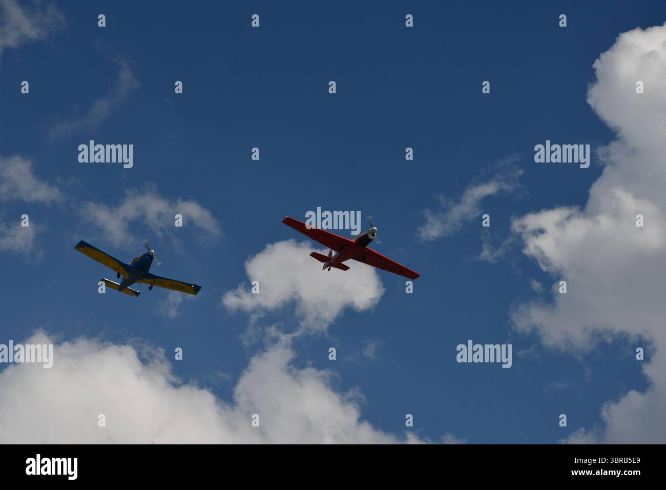 Due aerei aerobatici eseguono un volo di formazione attraverso nuvole sparse durante uno spettacolo di aviazione. Foto Stock