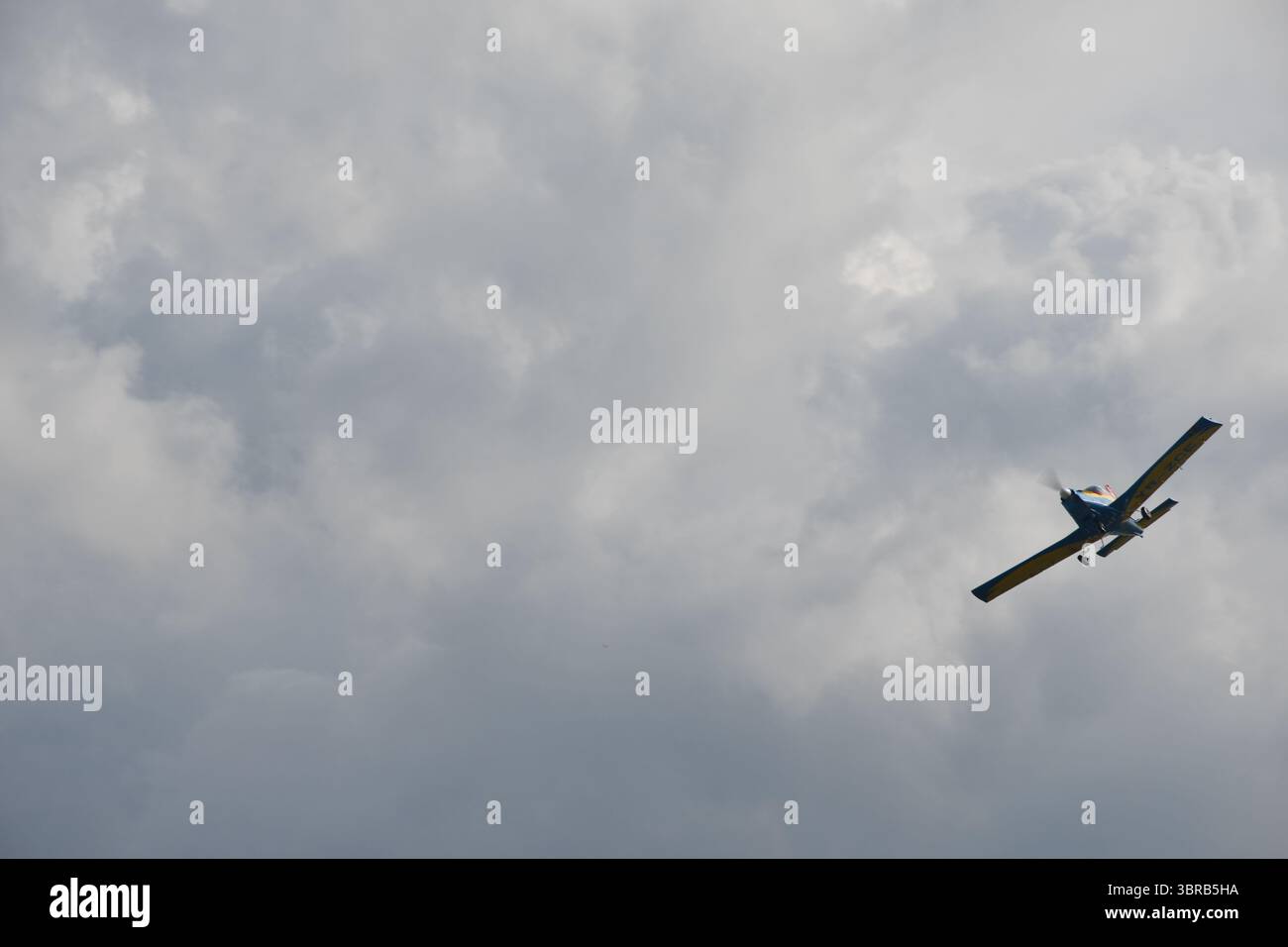 Un singolo aereo acrobatico sale nelle spettacolari nuvole di tempesta durante uno spettacolo aereo pubblico. Foto Stock
