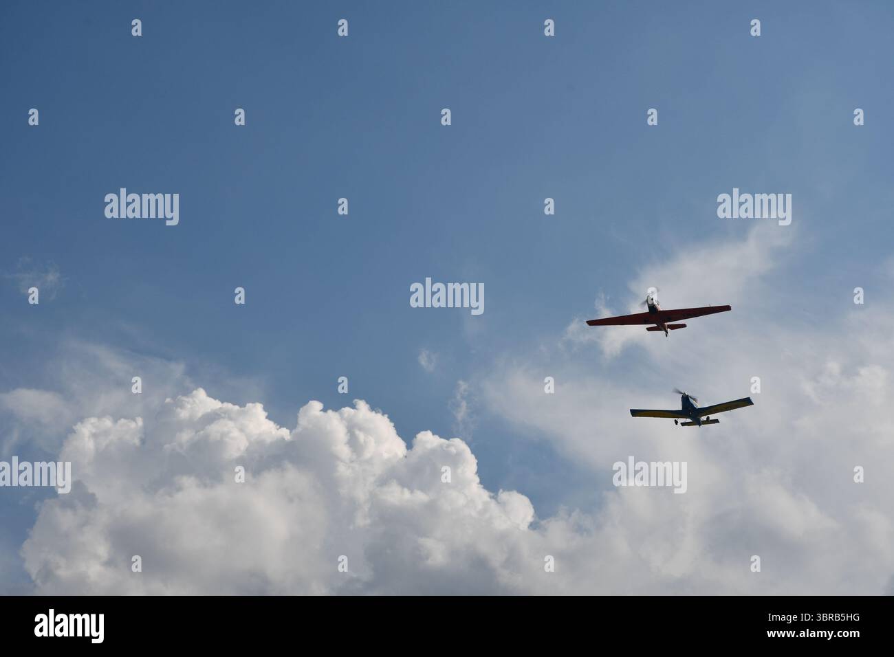 Due aerei aerobatici volano parallelamente in formazione durante uno spettacolo aereo sotto un cielo limpido. Foto Stock