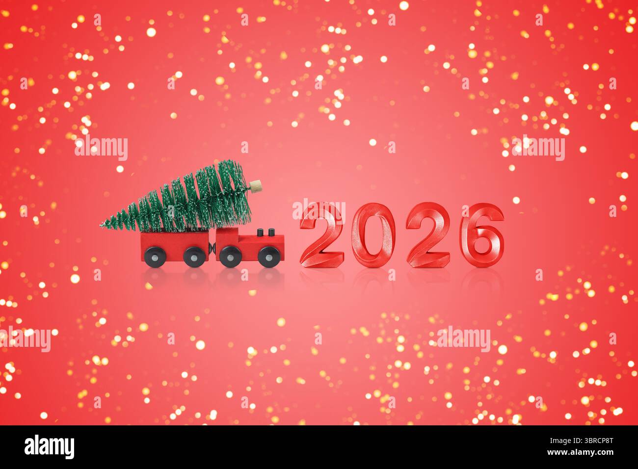 Biglietto di Natale. Anno nuovo 2026. Treno rosso con un albero di Natale e il numero 2026 su sfondo rosso con luci natalizie dorate. Concetto di "Happy ho" Foto Stock