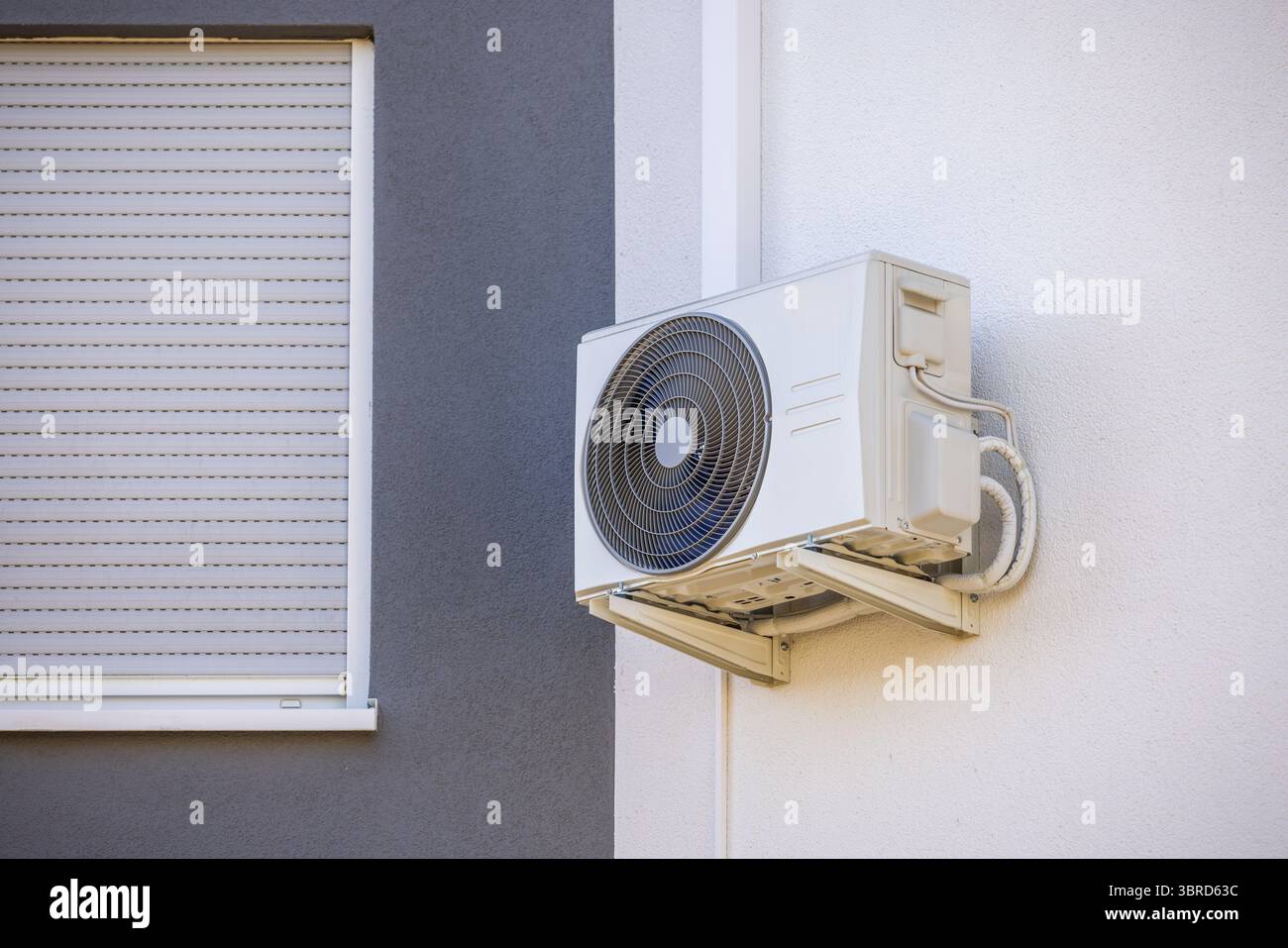 Condizionatore d'aria e pompa di calore installati su un muro di una casa di famiglia, unità con sistema diviso Foto Stock