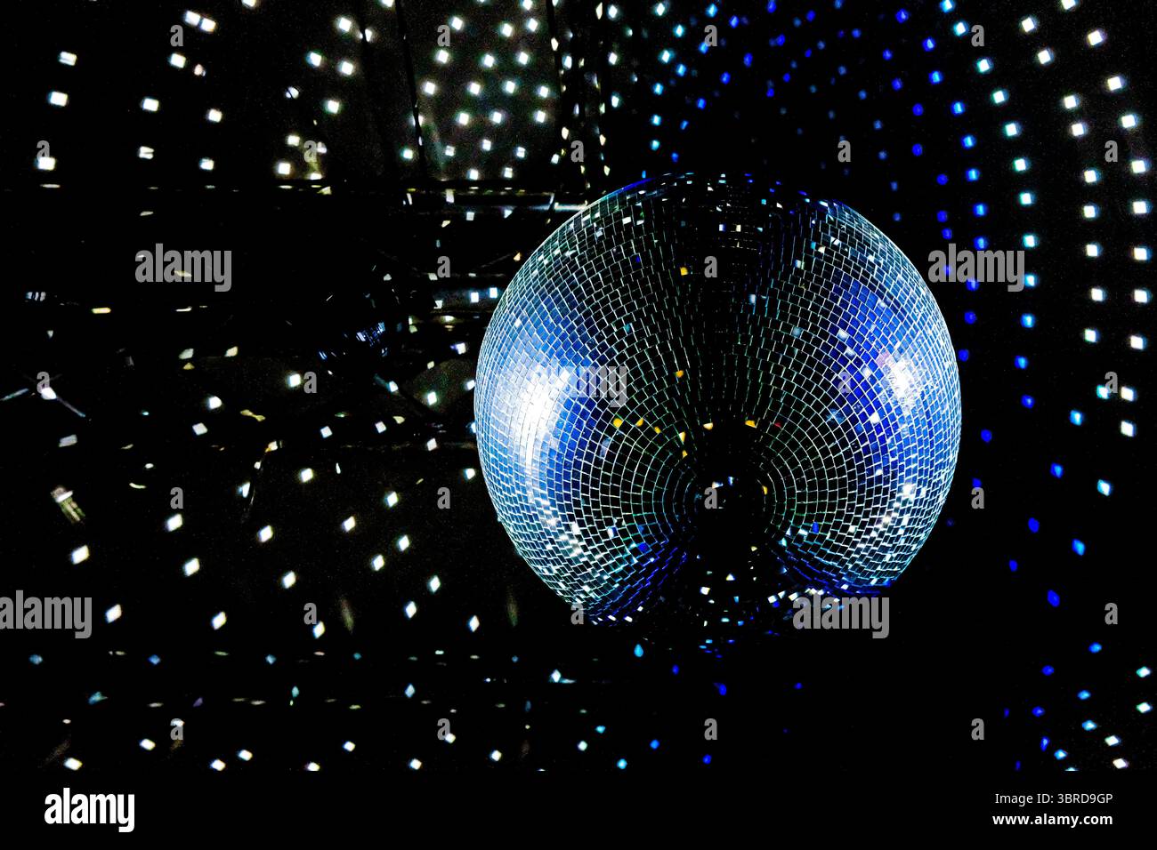Sfera da discoteca che riflette luce blu e viola. Festa, evento di ballo o atmosfera da night club. Copia spazio. Foto Stock