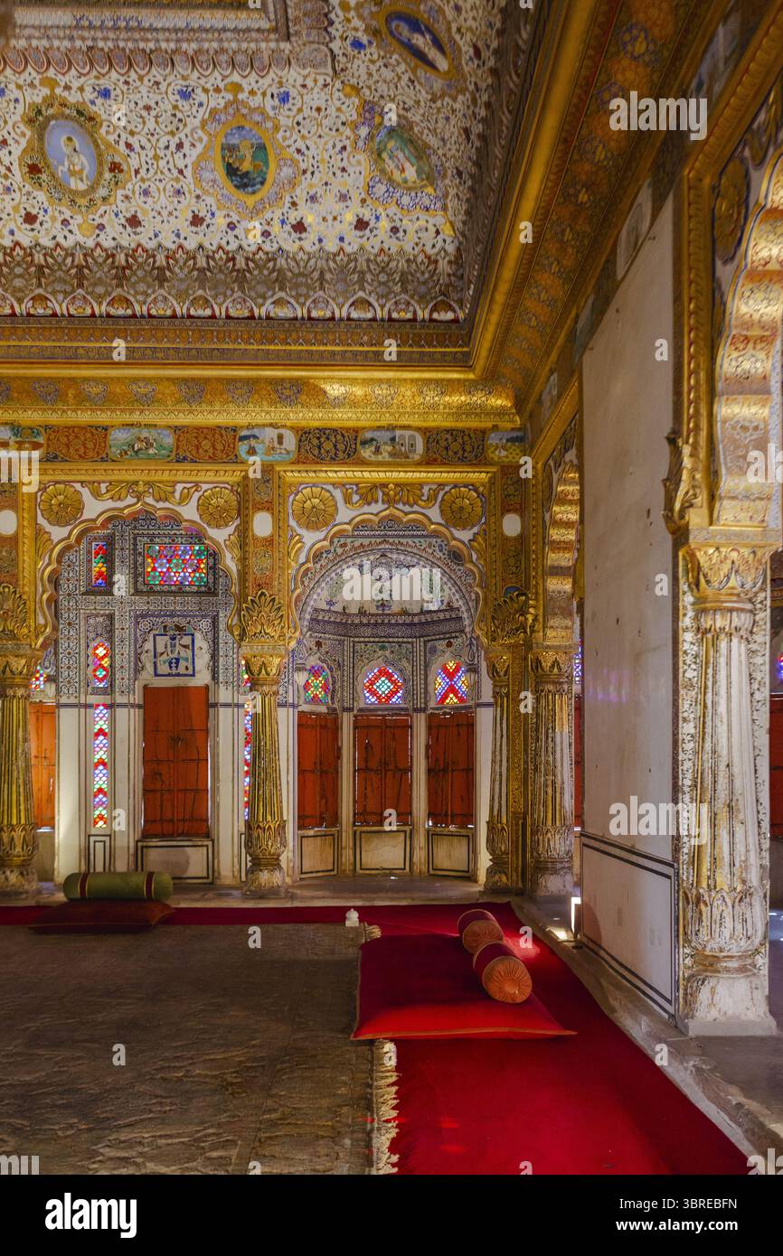 Vista di archi e colonne ornate, che riflettono il patrimonio reale indiano con intricate opere d'arte sul soffitto e un vibrante tappeto rosso, Jodhpur, Rajasthan, India. Foto Stock