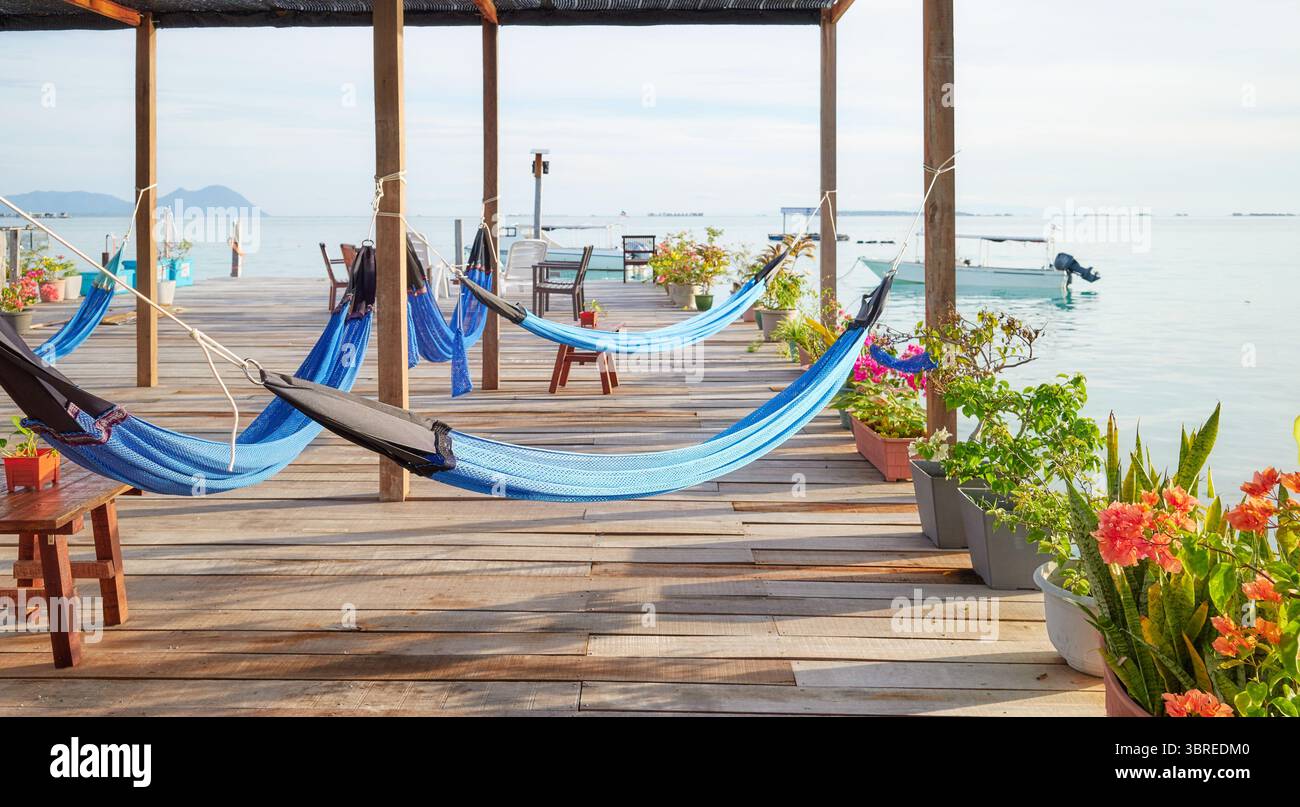 Amache su una piattaforma di legno sull'acqua, concetto di relax per le vacanze, quartiere di Semporna, Borneo, Malesia. Foto Stock