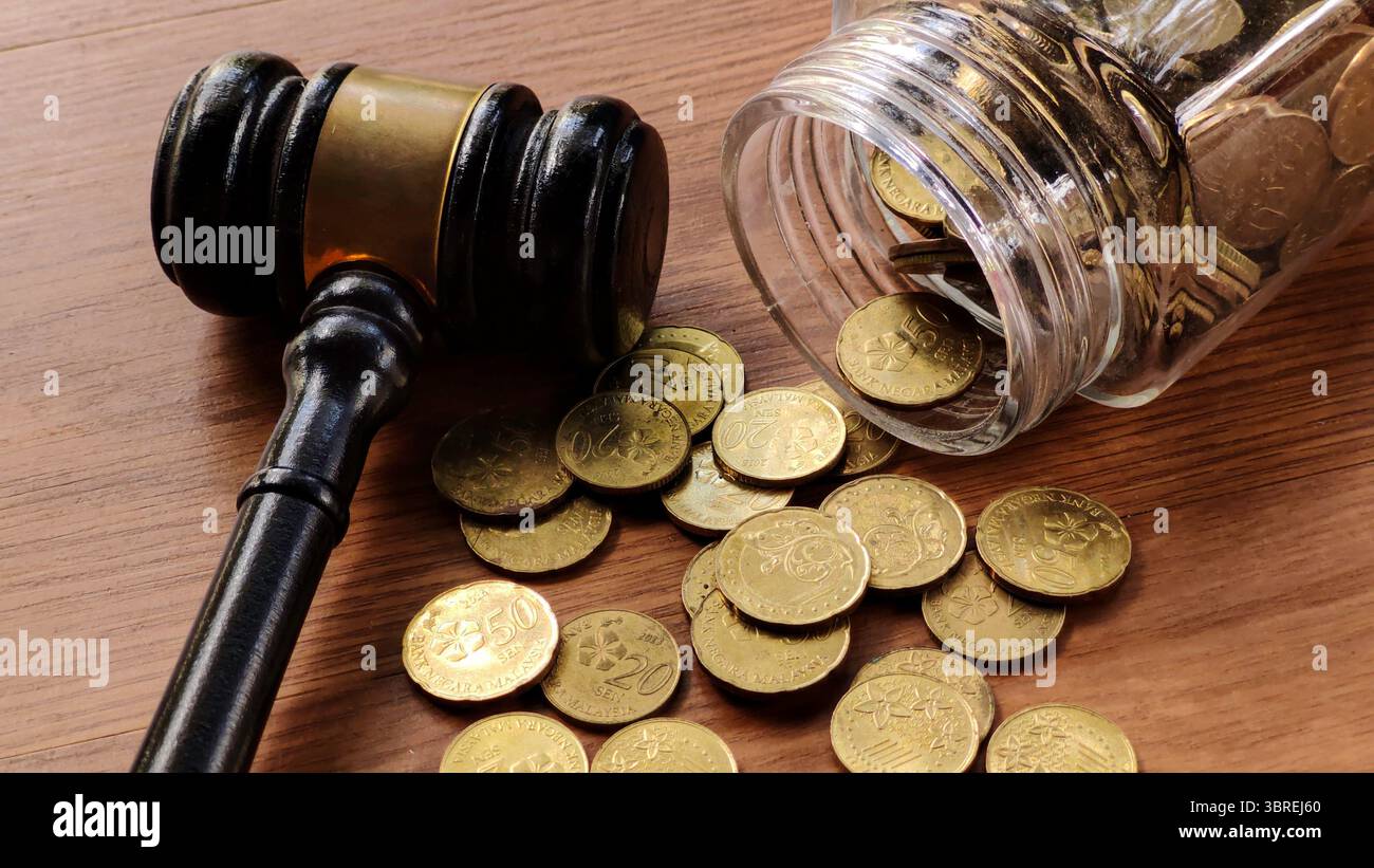 Martelletto e vaso di monete su tavola di legno Foto Stock
