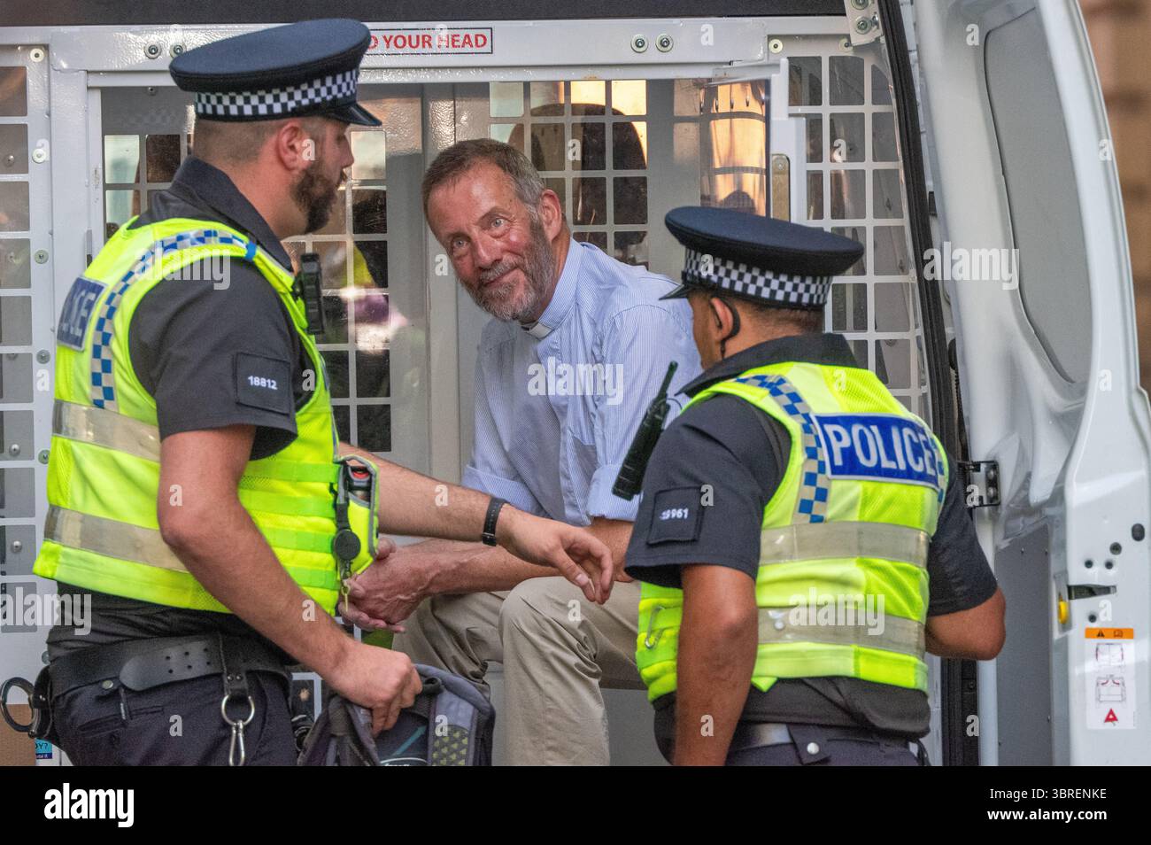 Un uomo con un "collare da cane" impiegato siede sul retro di un furgone della polizia. Dopo il suo arresto per aver tenuto uno striscione a sostegno dell'azione palestinese. Palestine Action arresta Manchester UK a "difendere la nostra protesta delle giurie" a sostegno del gruppo vietato Palestine Action . Più di una dozzina di manifestanti sono stati portati via dalla polizia in furgoni dopo essere stati rimossi da una protesta in piazza San Pietro dalla statua di Emmeline Pankhurst. I parlamentari britannici hanno votato per vietare l'azione palestinese come gruppo terroristico. Alla protesta che ha portato agli arresti si sono svolti cartelli d'azione per la Palestina. Molti di quelli portati via indossavano collari per cani. Manch Foto Stock