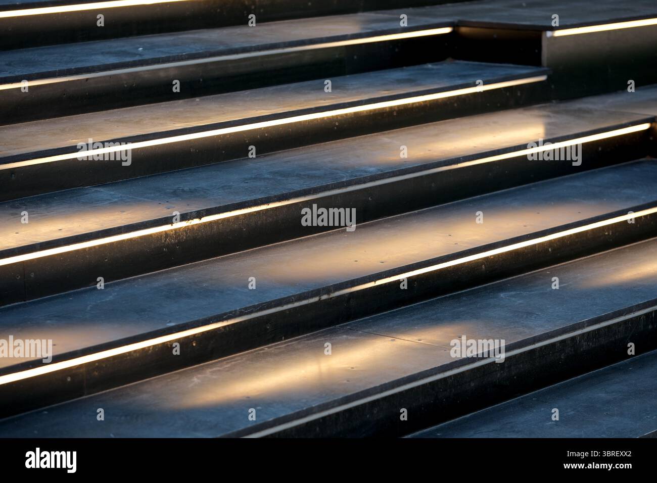 La luce soffusa mette in risalto le linee eleganti delle scale contemporanee al tramonto. Foto Stock