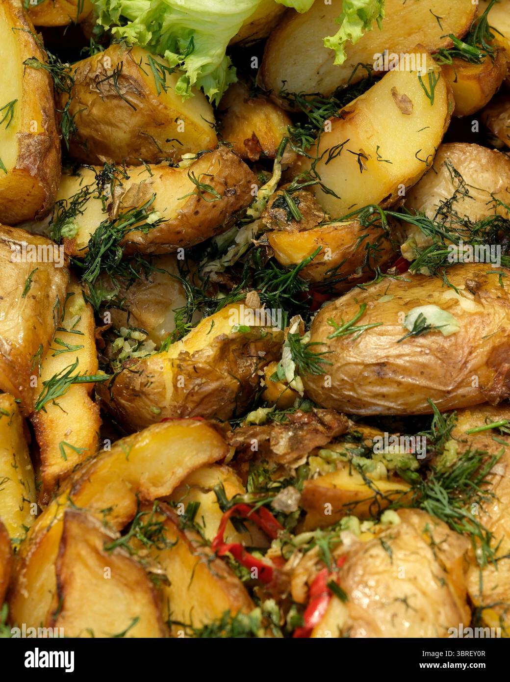 Patate dorate arrostite con erbe aromatiche, perfette per un pasto abbondante. Foto Stock