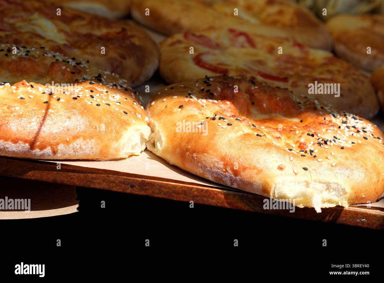 Ampia scelta di deliziosi panini con semi di sesamo e formaggio cotto alla perfezione. Foto Stock