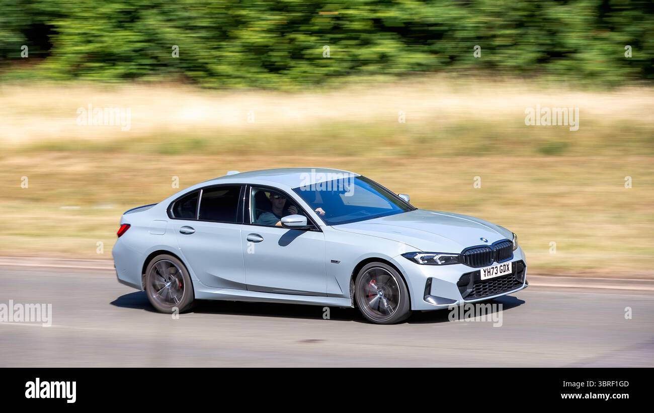 Milton Keynes,Bucks,UK - 12 luglio 2025: 2023 BMW 330e m auto elettrica ibrida sportiva che guida su una strada britannica Foto Stock
