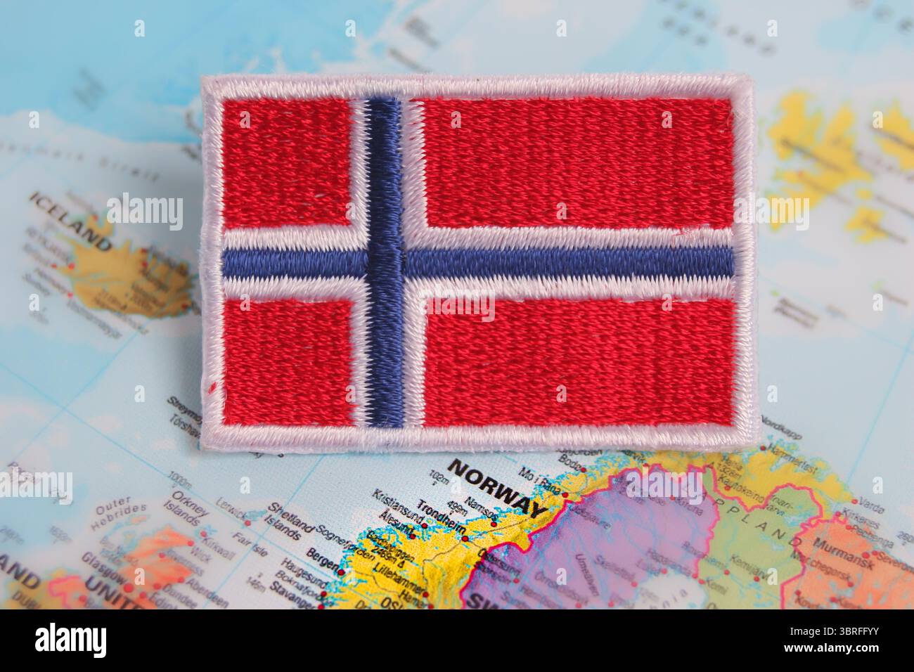 Bandiera della Norvegia ricamata ecologica, posizionata sulla mappa mondiale dell'Europa, che mette in evidenza il concetto di posizione del paese, la natura viaggia un'identità sostenibile. Foto Stock