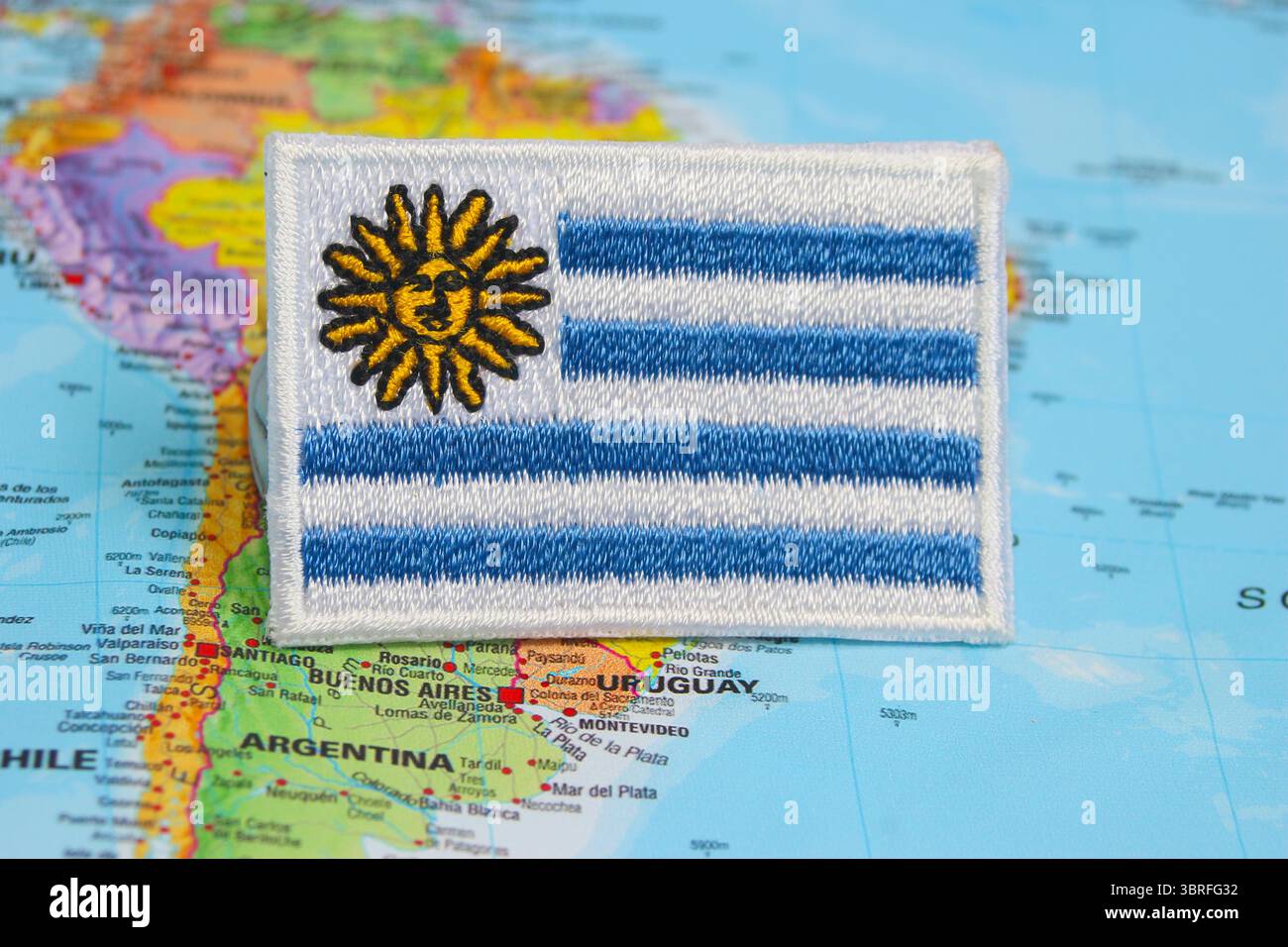 Bandiera uruguaiana ecologica realizzata in tessuto e filo su una mappa del mondo, che mostra la posizione del paese in Sud America con vibrazioni di viaggio naturali Foto Stock