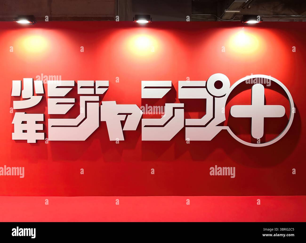 tokyo, isola di tennozu - 8 maggio 2025: Logo giapponese in rilievo illuminato su una parete rossa all'ingresso della mostra che celebra lo Shonen Jump Plus Foto Stock