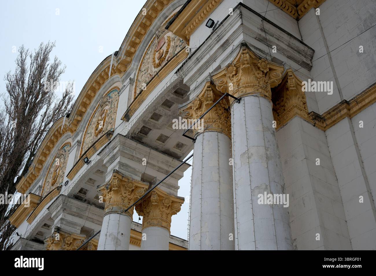 Maestose colonne si innalzano sopra, mostrando dettagli ornamentali contro la neve. Foto Stock