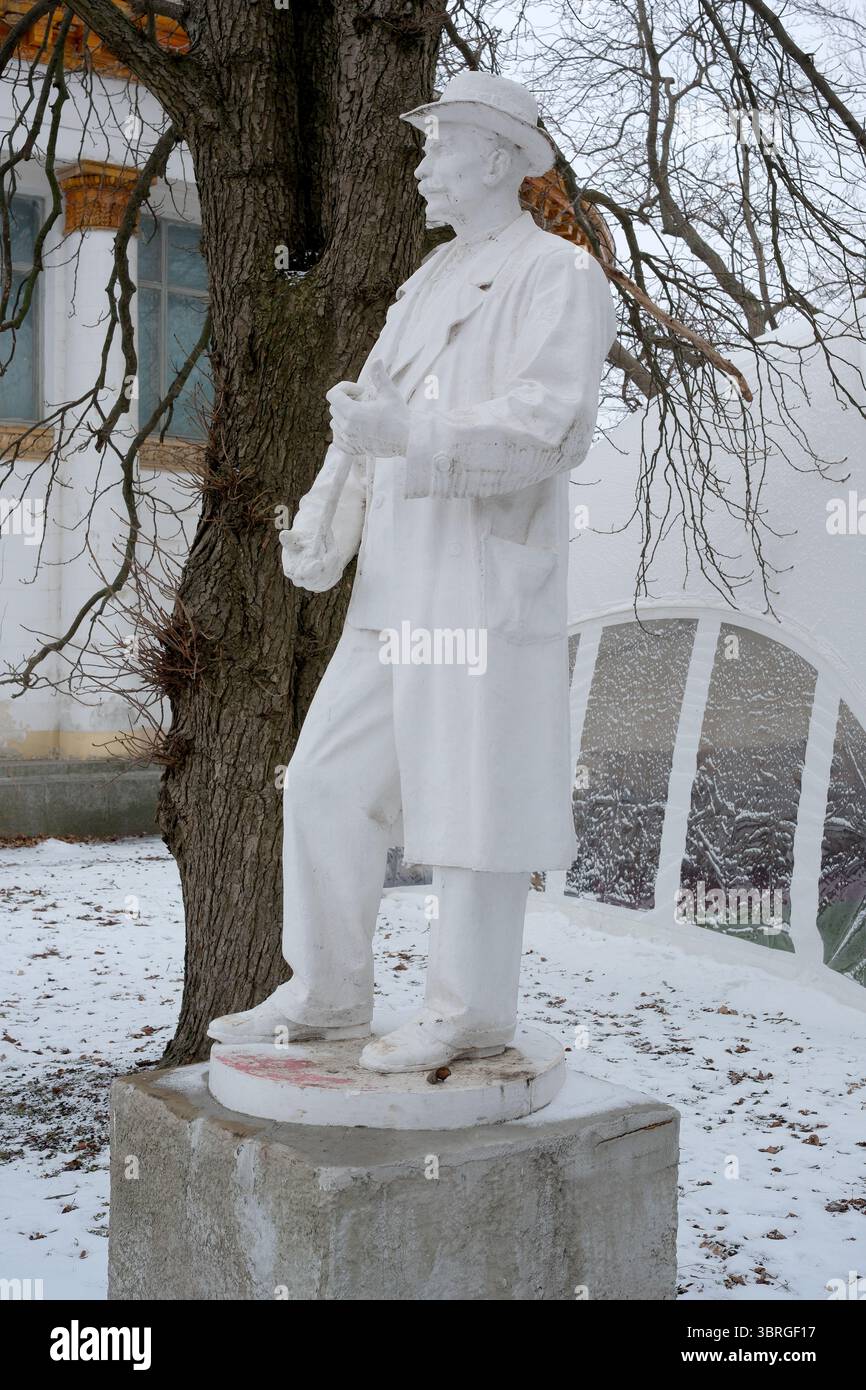 Una statua bianca si distingue nel paesaggio innevato, unendo arte e natura. Foto Stock