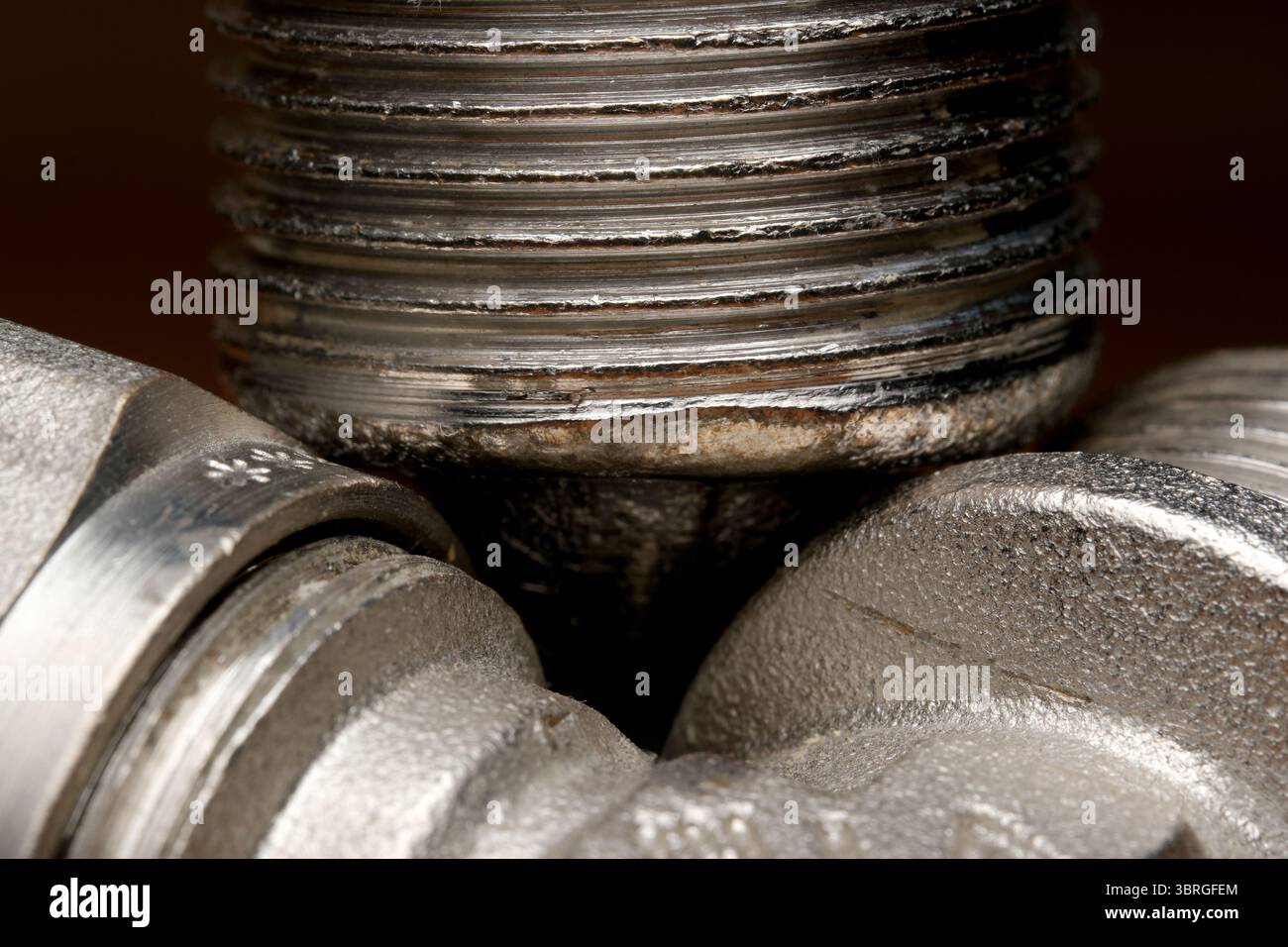 Primo piano di parti metalliche filettate che mostrano texture e dettagli di usura. Foto Stock