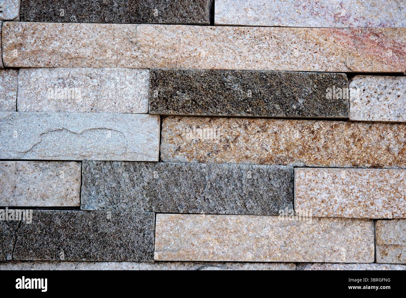 Diverse tonalità di pietra si fondono insieme, mostrando bellezza e consistenza naturali. Foto Stock