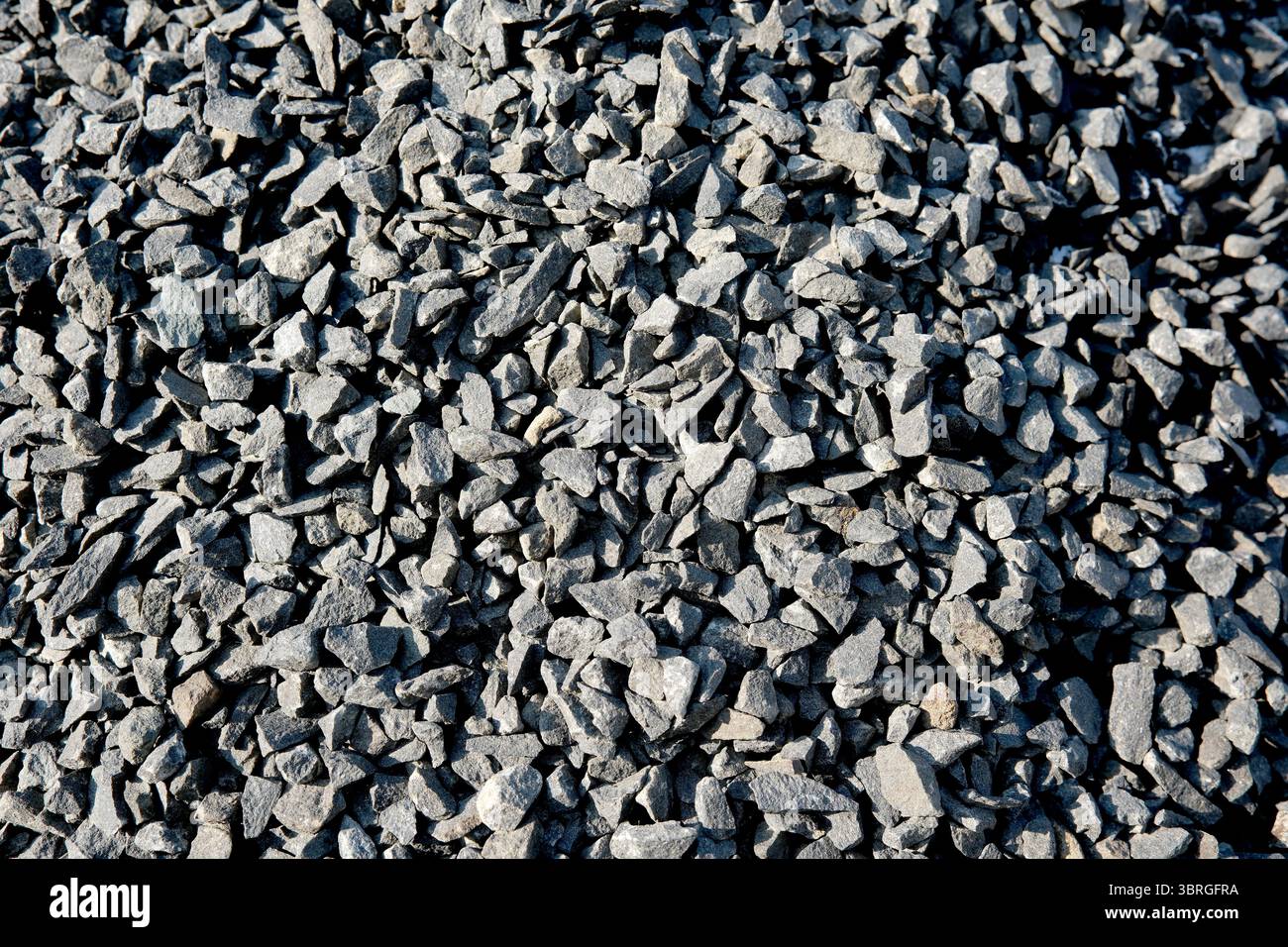 Pile di pietre nere frantumate offrono texture e contrasto per i giardini. Foto Stock
