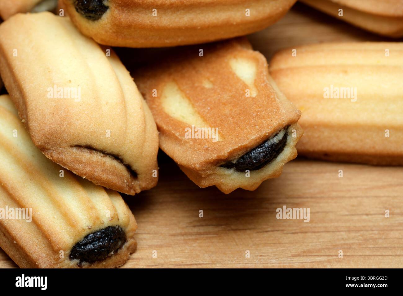 Una deliziosa collezione di biscotti madeleine, che mostrano la loro crosta marrone dorata e la consistenza morbida e burrosa. Questi dolcetti sono perfetti da abbinare Foto Stock