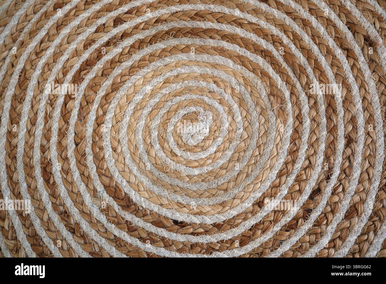 Il tappeto a spirale è realizzato in modo splendido e presenta fibre naturali dai toni terrosi. Foto Stock