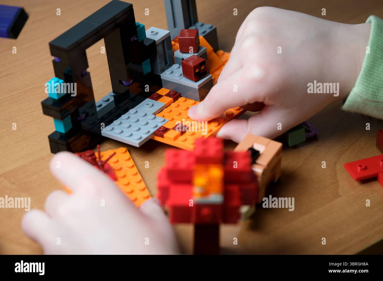 Le mani costruiscono abilmente blocchi vibranti in una struttura creativa. Foto Stock