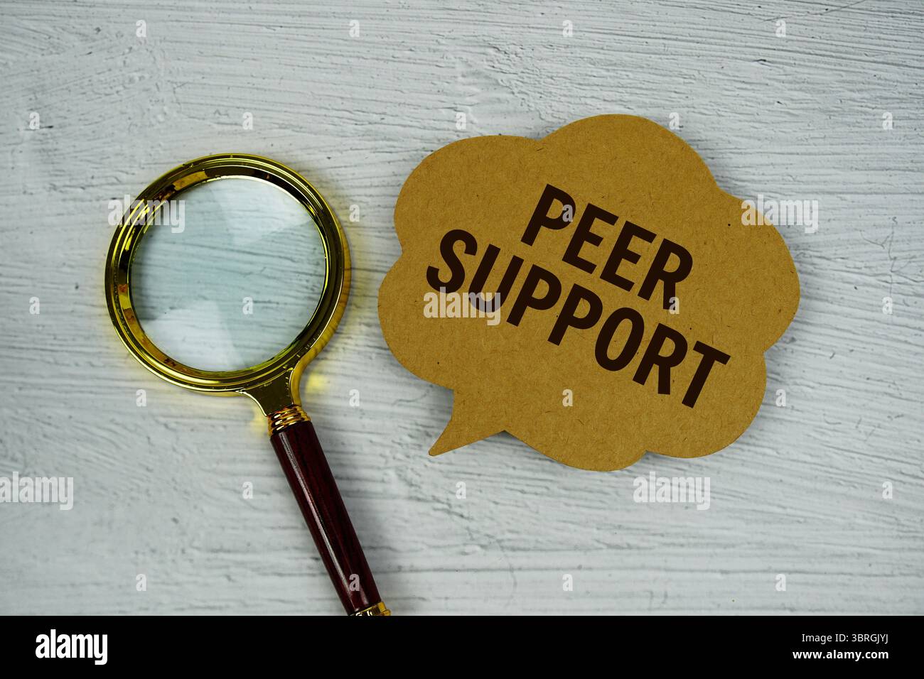 Testo di supporto peer su bolla vocale con lente d'ingrandimento su sfondo in cemento Foto Stock