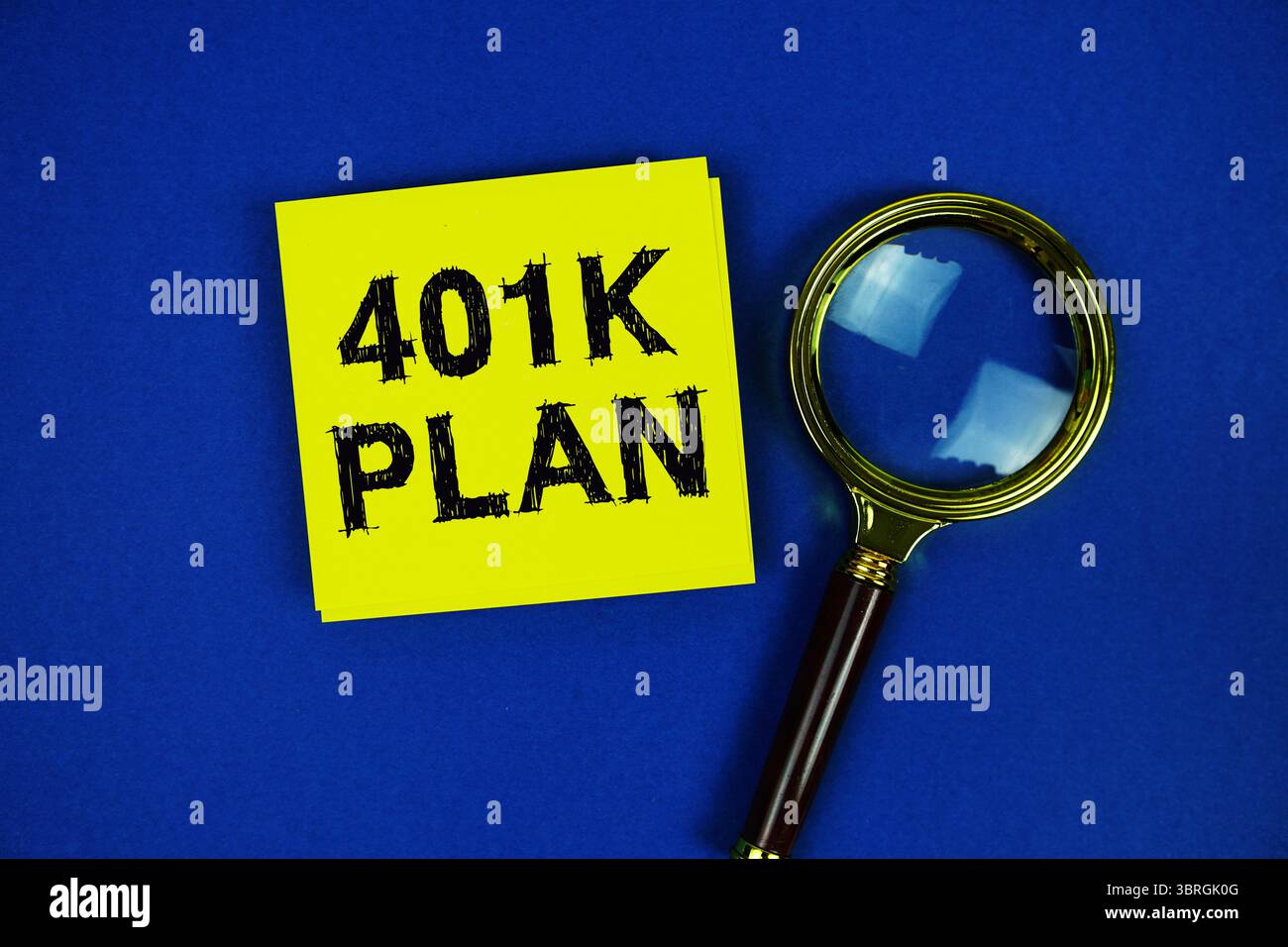 401K testo del piano su una nota adesiva con lente di ingrandimento su sfondo blu scuro Foto Stock