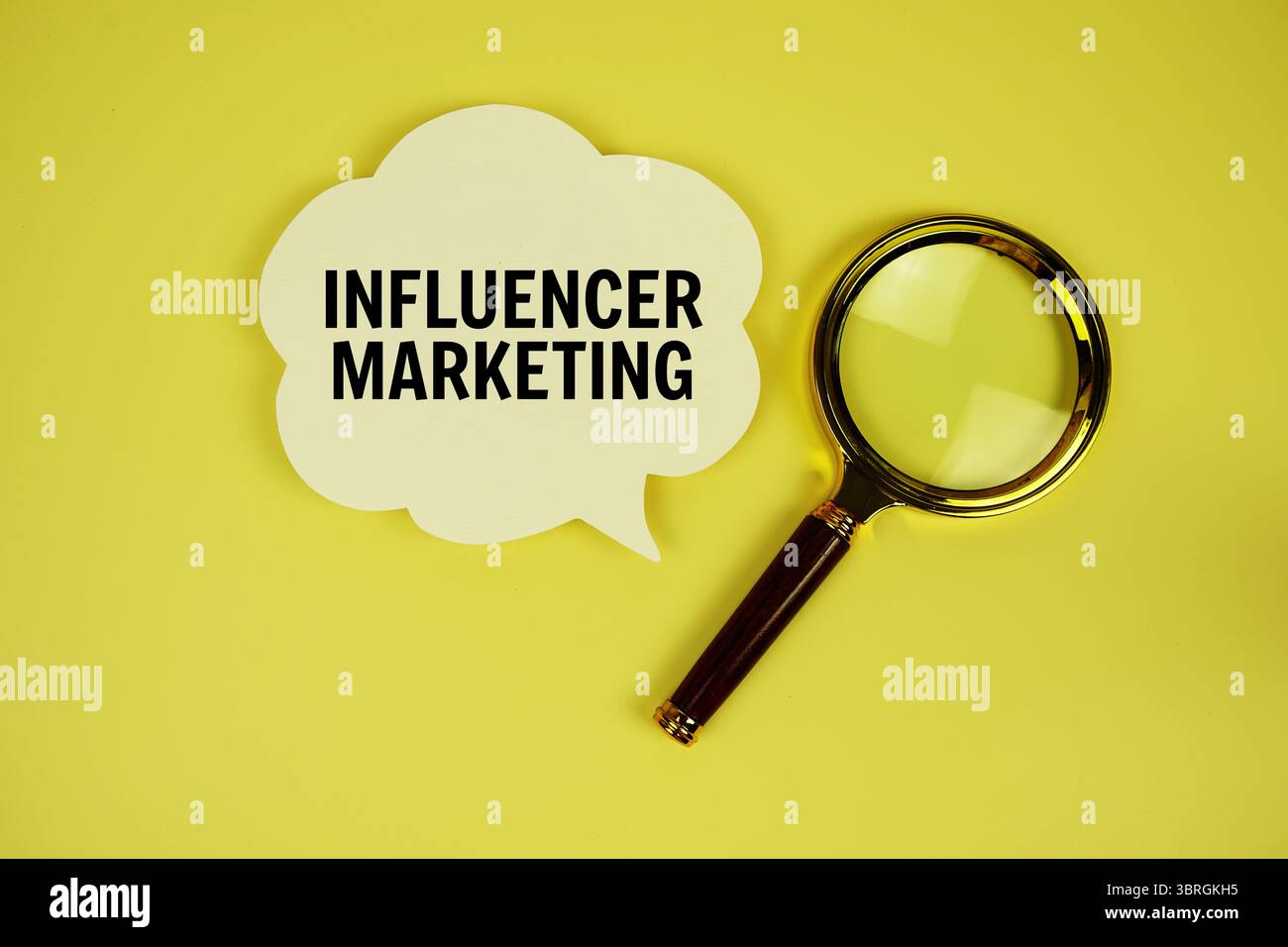 Testo di Influencer Marketing con bolla vocale e lente di ingrandimento su sfondo giallo Foto Stock