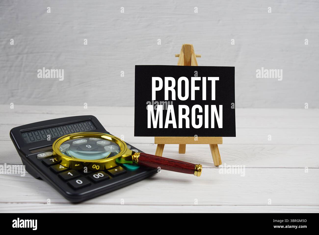 Testo del margine di profitto con lente d'ingrandimento e calcolatrice su sfondo in legno Foto Stock