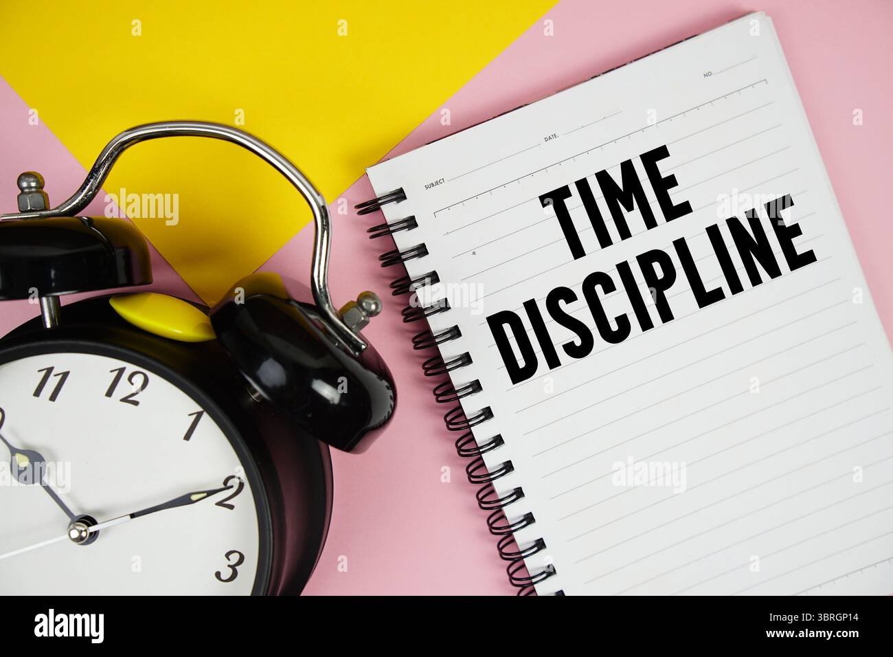 Testo sulla disciplina del tempo scritto su blocco note con sveglia su sfondo rosa Foto Stock