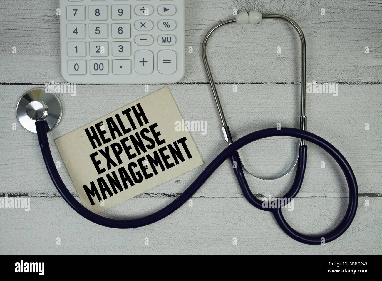 Testo di gestione delle spese sanitarie con stetoscopio e calcolatrice su sfondo in legno Foto Stock