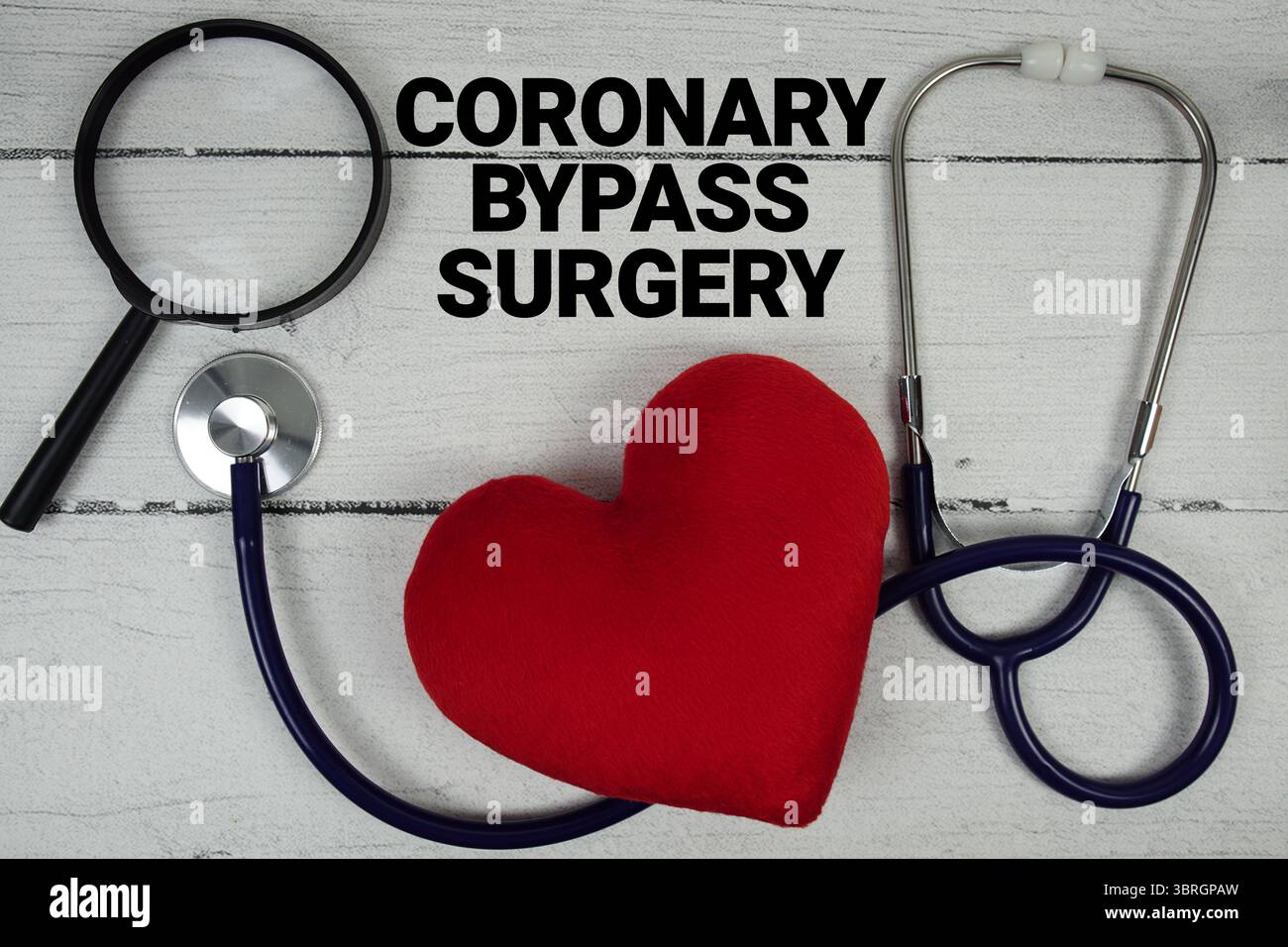 Bypass coronarico testo chirurgia con cuore rosso, vetro ingrandente e stetoscopio medico su sfondo in legno Foto Stock