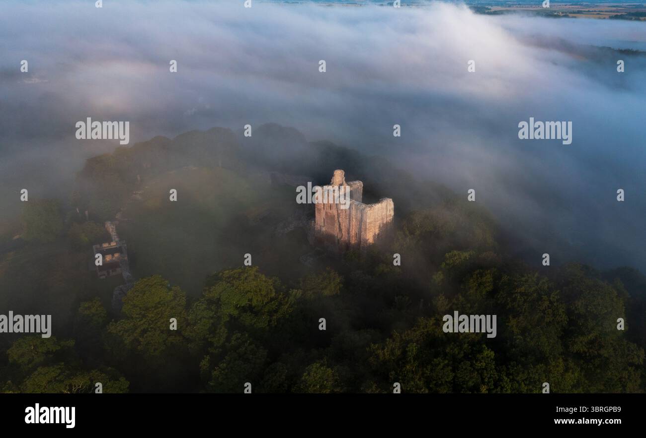 Castello di Norham uno dei più importanti castelli di confine nella nebbia estiva sul fiume Tweed Foto Stock